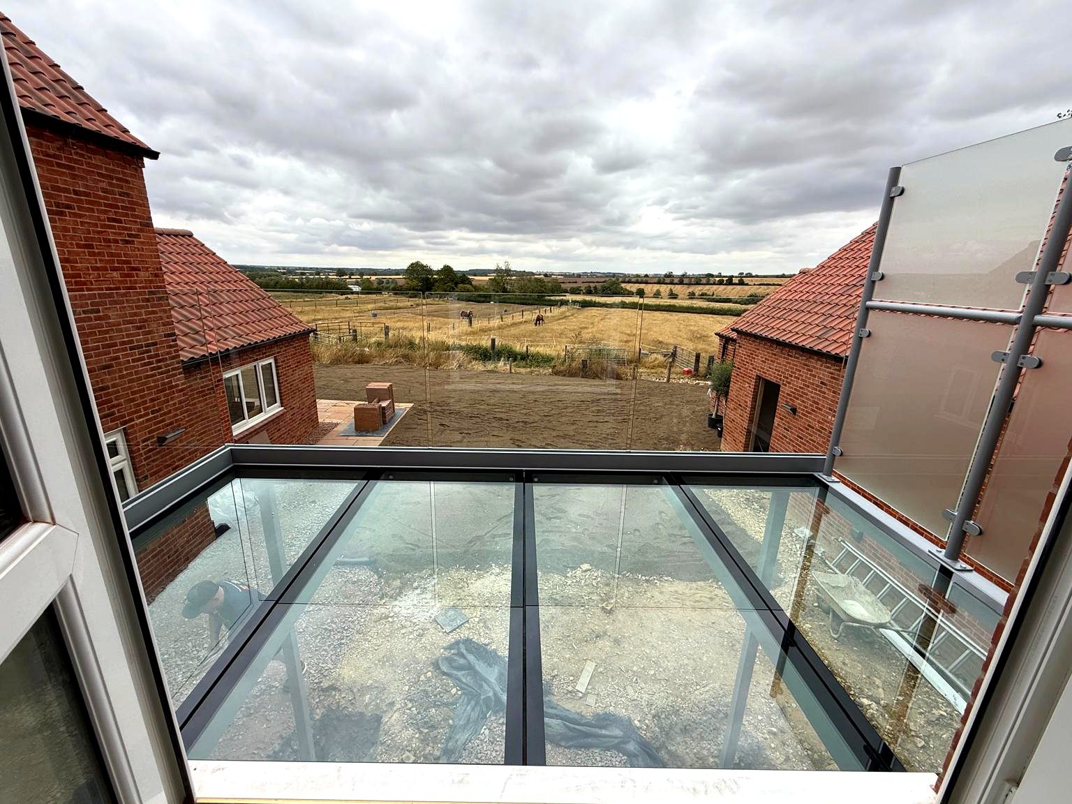 View from the doorway across a walk-on glass floor balcony to open countryside, Rutland